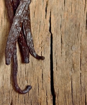 Bourbon vanilla beans isolated on old wooden background
