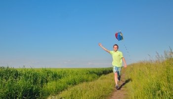 boy  running with kite in the field