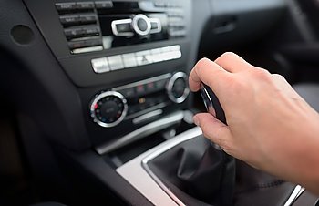 Driver shifting the gear stick inside of car