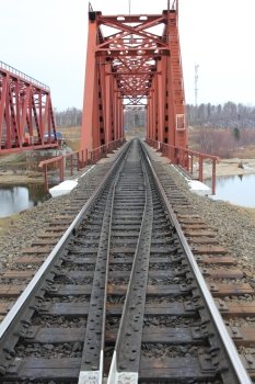 Red metal railway bridge across the river.
