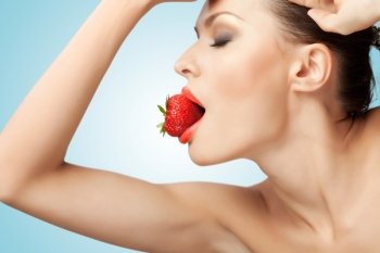 A portrait of a nude sexy woman holding a red-ripe strawberry in her mouth.