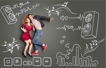 Happy valentines love story concept of a romantic couple sharing headphones and listening to the music against chalk drawings background of acoustic system, equalizer and player icons.
