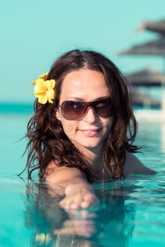 Beautiful young woman relax in swimming pool on tropical resort. Summer vacations concept