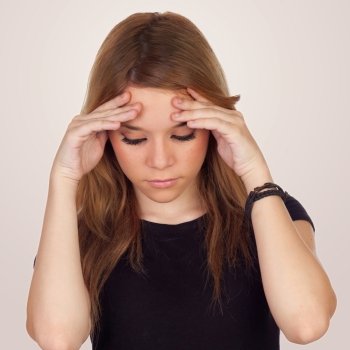 Teenager girl with migraine isolated on grey background
