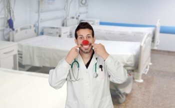 Doctor with a clown nose in the hospital with the beds of background