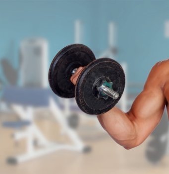 Muscled arm lifting weights in the gym