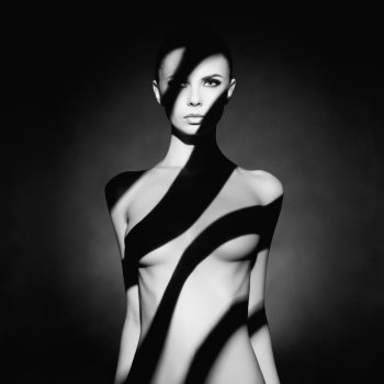 Fashion art studio portrait of elegant naked lady with shadow on her body