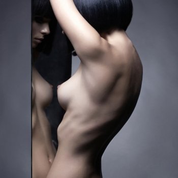 Fashion studio portrait of nude elegant woman and mirrors on black background