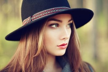 Portrait of young beautiful woman in autumn coat. Girl in hat. Fashion photo