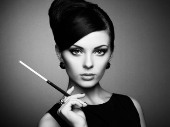 Portrait of beautiful sensual woman with elegant hairstyle.  Woman with cigarette Perfect makeup. Fashion photo. Black and white photo