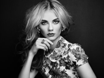 Portrait of beautiful sensual woman with elegant hairstyle.  Perfect makeup. Blonde girl. Fashion photo. Jewelry and dress. Black and white