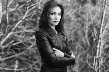 Portrait of young beautiful woman in leather jacket. Fashion photo. Black and white