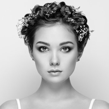Face of beautiful woman decorated with flowers. Perfect makeup. Beauty fashion. Eyelashes. Cosmetic Eyeshadow. Black and white