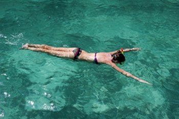 Young girl swimming in the turquoise water