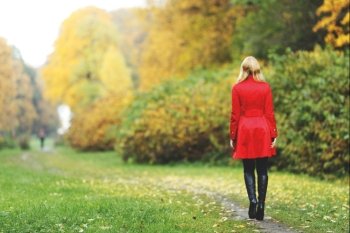 Rear view of walking  woman in autumn park