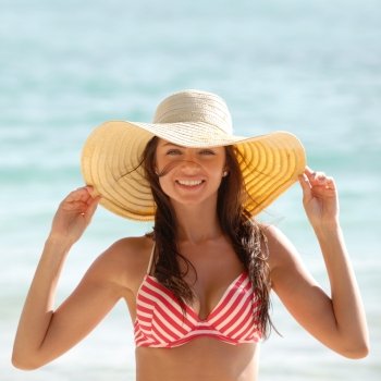 Woman in sunhat on beach. Portrait of a beautiful young woman in sunhat on beach