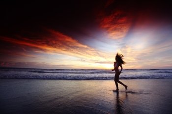 Happy woman running on the beach at sunset, Bali, Seminyak, Double six beach
