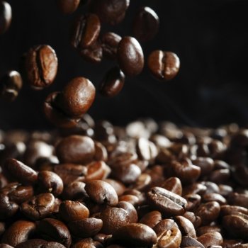 Falling roasted coffee beans on black background