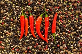 Red and green peppers on pepper background