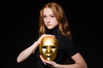 Redhead woman iwith mask in hypocrisy consept against black  background