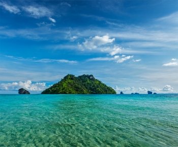 Vacation holidays concept background - tropical island and long-tail boat in sea. Thailand