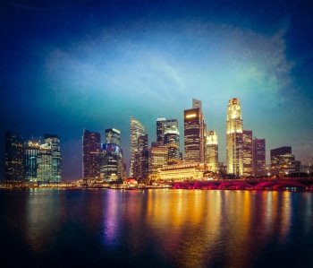 Vintage retro hipster style travel image of Singapore skyline and Marina Bay in evening