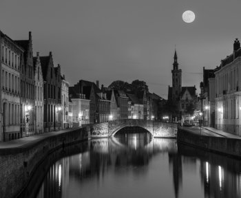 European medieval night city view background - Bruges Brugge canal in the evening, Belgium. Black and white version