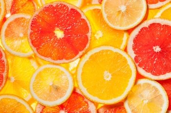 Colorful citrus fruit - lemon, orange, grapefruit - slices background. Backlit