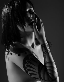 Enigmatic Glamorous Woman Vamp with Tattoo on her Arm