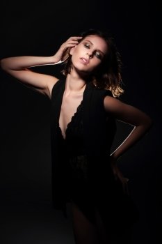 Model posing on a dark background, shadow, lighting.