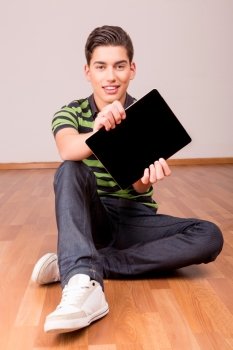 Happy young boy presenting your product in a tablet computer