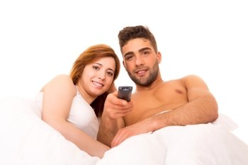 Happy couple watching television in bed