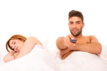 Couple in bed - Man is watching television and woman doesn’t like it