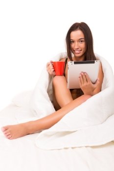 Beautiful young asian woman holding a cup of tea or coffee in bed
