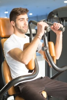 Handsome young man working out at the gym