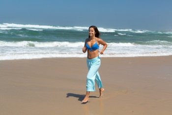 Beautiful woman exercising at the beach - fitness concept