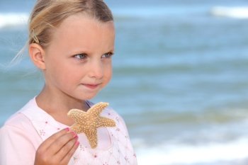 Young girl holding a starfish