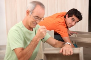 Grandfather helping grandson with the furniture