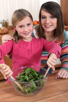 mother and daughter making salad