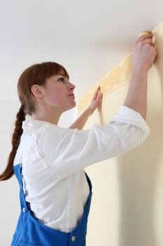 Woman gluing wallpaper border
