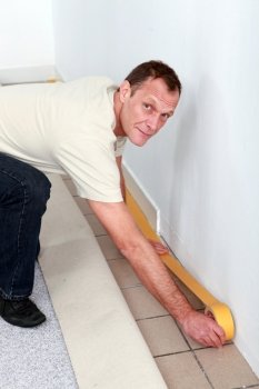 Man making preparations to fit new carpet