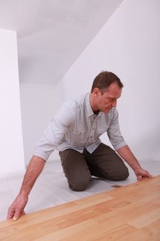 Man installing wooden flooring