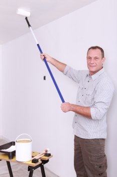 Man painting ceiling with roller