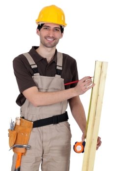 Handyman measuring a wooden plank