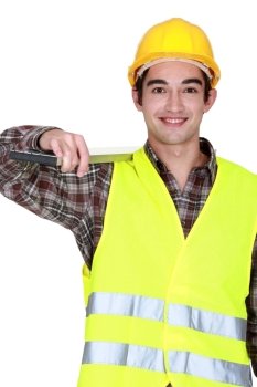 Construction worker carrying a heavy plank