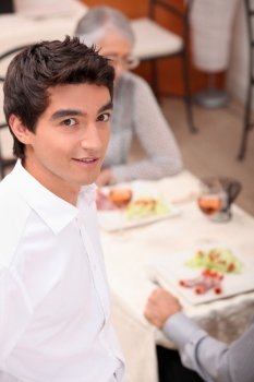 Young waiter serving lunch