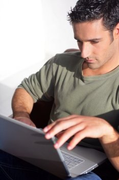 Dark haired man sat with laptop