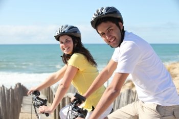 young couple riding near seafront
