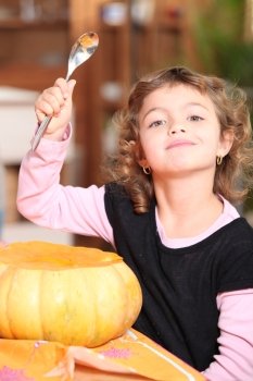 young girl carving a pumpkin