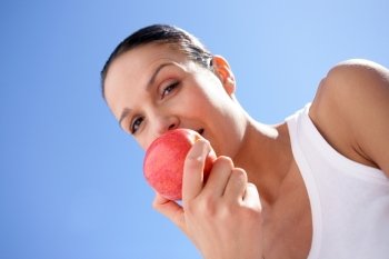 Brunette biting into red apple